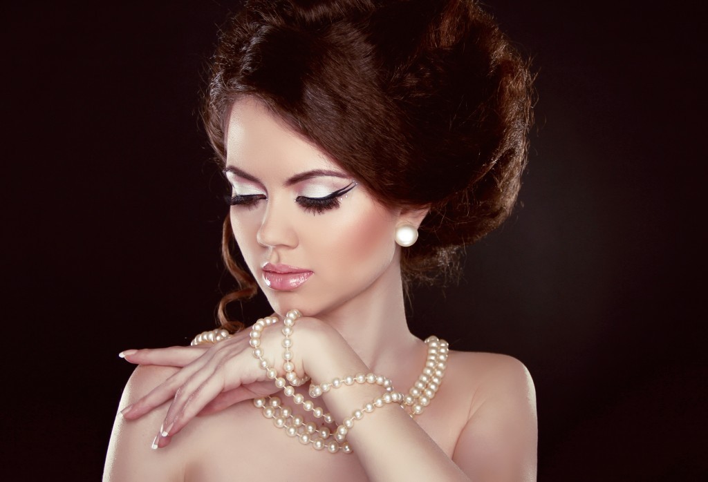 woman wearing strings of pearls on neck and wrist