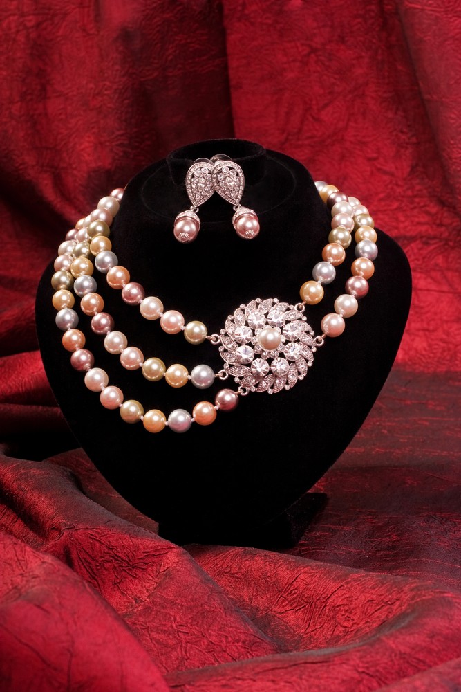 Pearl choker and earring on a red background