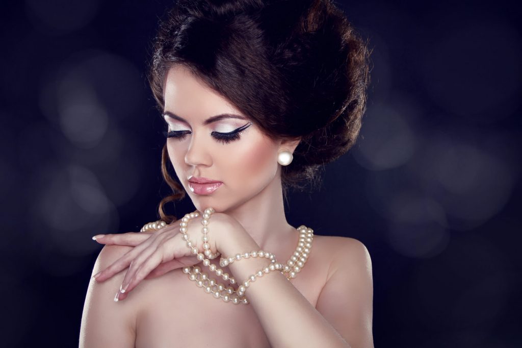woman wearing layers of pearl necklaces