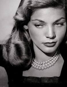 lauren bacall wearing triple strand pearl necklace